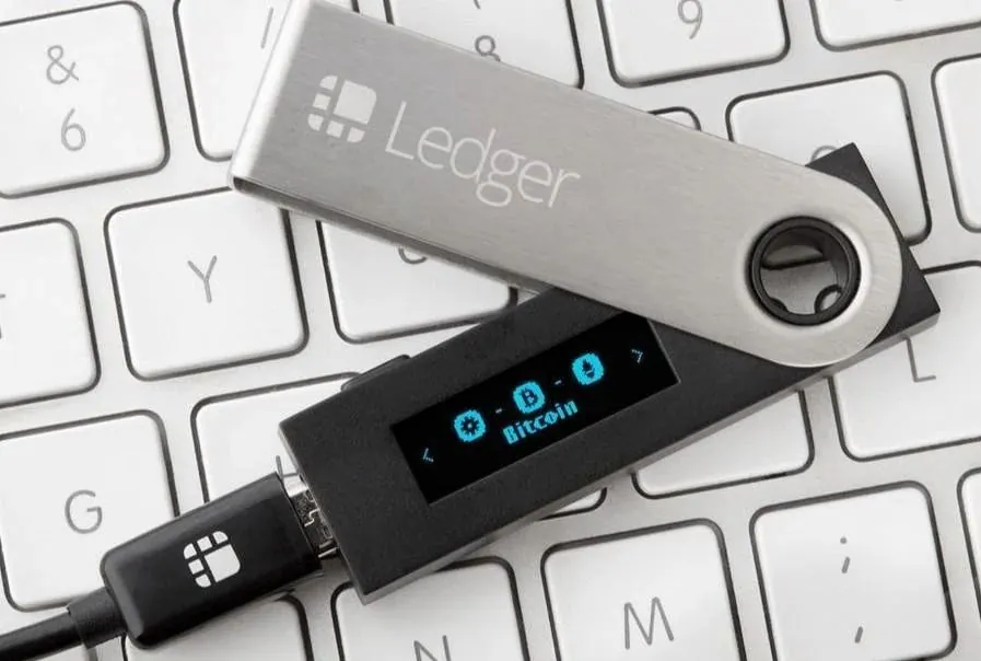 Billetera de hardware Ledger conectada por cable sobre un teclado
